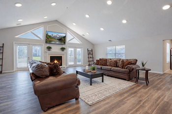 A cozy living room with a fireplace and a large couch.